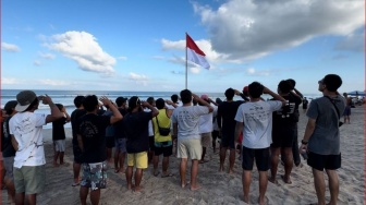 Peselancar Anak-Anak Ikuti Upacara Bendera 17 Agustus di Tepi Pantai Kuta