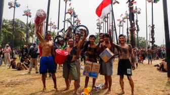 Peserta mengikuti lomba panjat pinang di Pantai Festival, Taman Impian Jaya Ancol, Jakarta, Sabtu (17/8/2024). [Suara.com/Alfian Winanto]