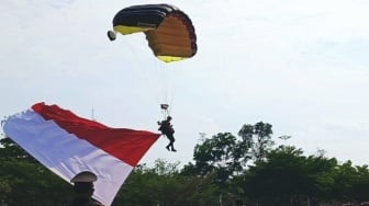 Delapan Penerjun Payung Brimob Kibarkan Bendera Merah Putih di Langit OKU Timur