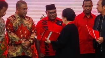 Ketua Umum PDI Perjuangan Megawati Soekarnoputri (kanan) menyerahkan surat rekomendasi partai kepada Bakal Calon Gubernur Papua Tengah Meki Fritz Nawipa (tengah) saat acara pengumuman para Calon Kepala Daerah di Kantor DPP PDIP, Jakarta, Kamis (22/8/2024). [Suara.com/Alfian Winanto]
