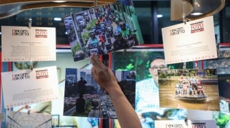 Pengunjung melihat karya foto yang dipamerkan pada pameran foto Rekam Jakarta di Perpustakaan Jakarta Galeri PDS HB Jassin, Taman Ismail Marzuki (TIM), Jakarta, Sabtu (24/08/2024). [Suara.com/Alfian Winanto]