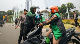 Massa pengemudi ojek online atau ojek daring melakukan aksi sweeping saat akan berunjuk rasa di kawasan Patung Kuda, Jakarta, Kamis (29/8/2024). [Suara.com/Alfian Winanto]