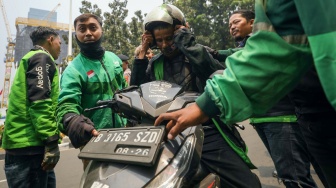 Massa pengemudi ojek online atau ojek daring melakukan aksi sweeping saat akan berunjuk rasa di kawasan Patung Kuda, Jakarta, Kamis (29/8/2024). [Suara.com/Alfian Winanto]