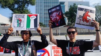 Peserta aksi mengangkat poster berisi kritikan saat menggelar aksi bela Palestina di depan Kedutaan Besar Amerika, Jakarta, Jumat (30/8/2024). [Suara.com/Alfian Winanto]