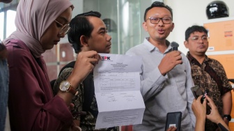 Sejumlah aktivis dari Koalisi Masyarakat Sipil untuk Reformasi Kepolisian menunjukan surat bukti pelaporan di Gedung Merah Putih KPK, Jakarta, Senin (2/9/2024). [Suara.com/Alfian Winanto]