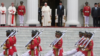 Tentara Kepresidenan berbaris melewati saat Presiden Indonesia Joko Widodo (tengah kanan) menerima Paus Fransiskus, sementara presiden terpilih Indonesia Prabowo Subianto (kedua dari kanan) terlihat saat upacara penyambutan di Istana Kepresidenan di Jakarta, Rabu (4/9/2024).[Adi WEDA / POOL / AFP]