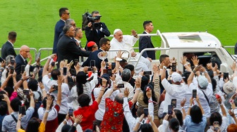 Pemimpin Takhta Suci Vatikan Paus Fransiskus menyapa umat Katolik sebelum mengikuti Misa di Stadion Utama Gelora Bilung Karno (GBK) Senayan, Jakarta, Kamis (5/9/2024). [Suara.com/Alfian Winanto]