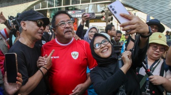 Bakal calon wakil gubernur Rano Karno berswafoto dengan warga saat CFD di Bundaran HI, Jakarta, Minggu (8/9/2024). [Suara.com/Alfian Winanto]