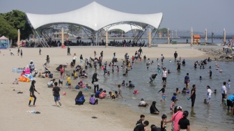 Pengunjung bermain air di Pantai Lagoon, Ancol Taman Impian, Jakarta, Senin (16/9/2024). [Suara.com/Alfian Winanto]