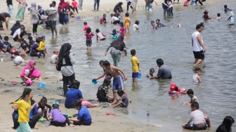 Pengunjung bermain air di Pantai Lagoon, Ancol Taman Impian, Jakarta, Senin (16/9/2024). [Suara.com/Alfian Winanto]