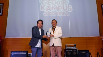 CEO Suara.com Suwarjono (kiri) memberikan plakat kepada Wakil Dekan III UNJ Abdul Haris (kanan) saat pembukaan acara Gedor Kampus Jakarta di Universitas Negeri Jakarta (UNJ), Selasa (17/9/2024). [Suara.com/Alfian Winanto]