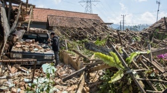 Warga membersihkan puing rumah yang runtuh pasca gempa bumi di Desa Cibeureum, Kertasari, Kabupaten Bandung, Jawa Barat, Rabu (18/9/2024). [ANTARA FOTO/Novrian Arbi/Spt]