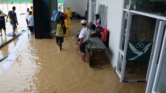 Ofisial mengevakuasi peralatan mereka dari venue lapangan tembak indoor SR 50 meter PON XXI Aceh-Sumut 2024 yang tergenang air di Lapangan Tembak Rindam IM Mata Ie, Aceh Besar, Aceh, Selasa (17/9/2024). [ANTARA FOTO/Arnas Padda/aww]