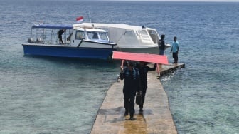 Petugas Pengawasan Sumber Daya Kelautan dan Perikanan (PSDKP) KKP mengusung papan penyegelan yang akan dipasang di resor Pulau Bukungan Kecil, Kepulauan Maratua, Kecamatan Maratua, Kabupaten Berau, Kalimantan Timur, Kamis (19/9/2024). [ANTARA FOTO/M Risyal Hidayat/YU]