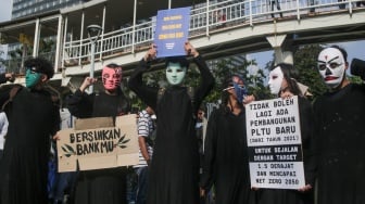 Aktivis lingkungan melakukan aksi di Jalan Sudirman, Jakarta, Jumat (27/9/2024). [Suara.com/Alfian Winanto]