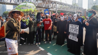 Aktivis lingkungan melakukan aksi di Jalan Sudirman, Jakarta, Jumat (27/9/2024). [Suara.com/Alfian Winanto]