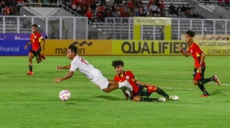 Pemain Timnas Indonesia U-20 Tony Firmansyah terjatuh usai dilanggar pemain Timnas Timor Leste U-20 dalam pertandingan kualifikasi Piala Asia U-20 grup F di Stadion Madya, Jakarta, Jumat (27/9/2024). [Suara.com/Alfian Winanto]