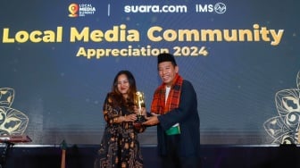 Pemimpin Redakai Suara.com Suwarjono (kanan) memberikan piagam penghargaan kepada perwakilan Bank Rakyat Indonesia (BRI) dalam sesi Appreciation Night di acara Local Media Summit 2024 di Hotel Sultan, Jakarta, Rabu (2/10/2024). [Suara.com/Alfian Winanto]