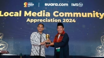 Pemimpin Redakai Suara.com Suwarjono (kanan) memberikan piagam penghargaan kepada Executive Vice President Komunikasi Korporat & TJSL PLN, Gregorius Adi Trianto (kiri) dalam sesi Appreciation Night di acara Local Media Summit 2024 di Hotel Sultan, Jakarta, Rabu (2/10/2024). [Suara.com/Alfian Winanto]