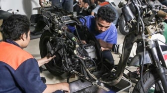 Teknisi mengonversi sepeda motor berbahan bakar minyak menjadi sepeda motor listrik di Bengkel Elders Garage, Jakarta, Jumat (4/10/2024). [Suara.com/Alfian Winanto]