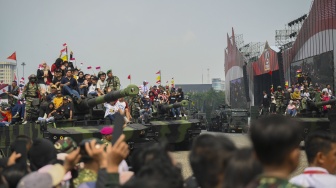 Warga naik tank saat peringatan Hari Ulang Tahun (HUT) ke-79 Tentara Nasional Indonesia (TNI) di Lapangan Silang Monumen Nasional (Monas), Gambir, Jakarta, Sabtu (5/10/2024). ANTARA FOTO/Fauzan]