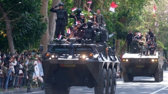 Sejumlah warga menaiki kendaraan tempur saat parade Alutsista pada peringatan Hari Ulang Tahun (HUT) ke-79 Tentara Nasional Indonesia (TNI) di Lapangan Puputan Margarana Niti Mandala, Denpasar, Bali, Sabtu (5/10/2024). [ANTARA FOTO/Nyoman Hendra Wibowo]