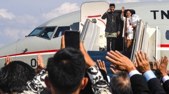 Presiden ketujuh RI Joko Widodo bersama Istri Iriana Joko Widodo memberi hormat dan salam saat akan memasuki pesawat Boeing 737 milik Angkatan Udara untuk bertolak ke Solo di Base Ops Lanud Halim Perdanakusuma, Jakarta, Minggu (20/10/2024). [ANTARA FOTO/Muhammad Adimaja/Spt]