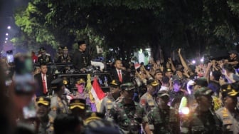 Mantan Presiden Jokowi menyapa ratusan ribu warga di ruas Jalan Adi Sucipto, Solo menuju kediaman pribadi kawasan Sumber, Banjarsari, Minggu (20/10/2024). [Suara.com/Ronald Seger Prabowo]