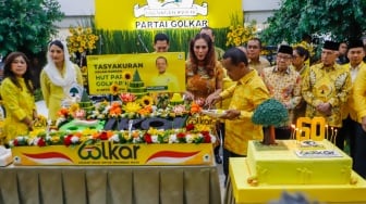 Ketua Umum Partai Golkar Bahlil Lahadalia (tengah) melakukan prosesi potong tumpeng saat perayaan HUT ke-60 Partai Golkar di Kantor DPP Golkar, Jakarta, Senin (21/10/2024). [Suara.com/Alfian Winanto]