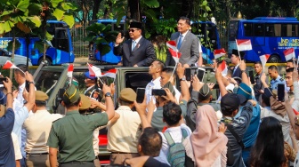 Presiden Prabowo Subianto (kiri) bersama Menteri Pertahanan Sjafrie Sjamsoeddin (kanan) menaiki mobil rantis Maung menyapa pegawai Kemenhan usai upacara serah terima jabatan (sertijab) Menhan di kantor Kementerian Pertahanan, Jakarta, Selasa (22/10/2024). [Suara.com/Alfian Winanto]