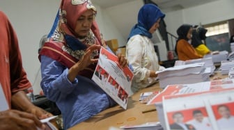 Sejumlah petugas melakukan pelipatan surat suara untuk pemilihan umum kepala daerah (Pilkada) di Gudang Logistik KPU Jakarta Pusat, Jakarta, Rabu (23/10/2024). [Suara.com/Alfian Winanto]