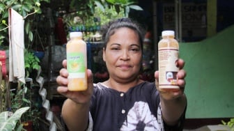 Pembuat minuman herbal Yuliana menunjukan produknya di Kampung Setaman, Kelurahan Ratu Jaya, Kecamatan Cipayung, Depok, Jawa Barat, Sabtu (26/10/2024). [Suara.com/Dwi Bowo Raharjo]