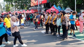 Warga berswafoto saat Car Free Day (CFD) di Bundaran HI, Jakarta, Minggu (27/10/2024). [Suara.com/Alfian Winanto]