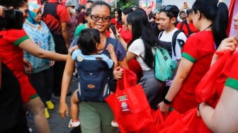 Warga antri untuk mendapatka  makanan gratis dalam acara Pucuk Coolinary Festiv saat Car Free Day di Bundaran HI, Jakarta, Minggu (27/10/2024). [Suara.com/Alfian Winanto]