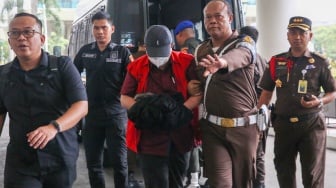 Petugas menggiring Hakim Pengadilan Negeri (PN) Surabaya Mangapul saat akan menjalani pemeriksaan sebagai tersangka kasus dugaan tindak pidana korupsi di Jakarta, Selasa (5/11/2024). [Suara.com/Alfian Winanto]