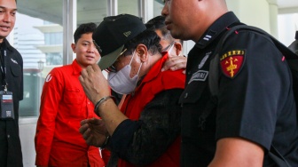 Petugas menggiring Hakim Pengadilan Negeri (PN) Surabaya Erintuah Damanik (tengah) saat akan menjalani pemeriksaan sebagai tersangka kasus dugaan tindak pidana korupsi di Jakarta, Selasa (5/11/2024). [Suara.com/Alfian Winanto]