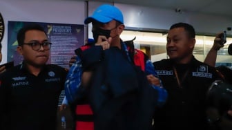 Petugas menggiring Hakim Pengadilan Negeri (PN) Surabaya Heru Hanindyo usai menjalani pemeriksaan sebagai tersangka kasus dugaan tindak pidana korupsi di Jakarta, Selasa (5/11/2024). [Suara.com/Alfian Winanto]