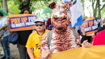 Sejumlah aktivis dari Aliansi Rakyat untuk Keadilan Iklim (ARUKI) melakukan aksi unjuk rasa di depan Kementerian Lingkungan Hidup, Jakarta, Senin (18/11/2024). [Suara.com/Alfian Winanto]