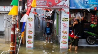 Warga beraktivitas di tengah banjir rob yang menggenangi wilayah Muara Angke, Jakarta Utara, Selasa (19/11/2024). [Suara.com/Alfian Winanto]