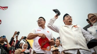 Calon Gubernur dan Wakil Gubernur DKI Jakarta nomor urut satu Ridwan Kamil (kiri) dan Suswono (kedua kanan) membagikan topi kepada pendukungnya dalam kampanye akbar terakhir di Lapangan Banteng, Jakarta, Sabtu (23/11/2024). [ANTARA FOTO/Aprillio Akbar/nz]