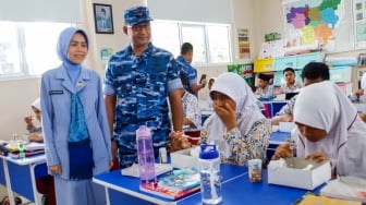 Komandan Lanud (Danlanud) Halim Perdanakusuma Marsma TNI Muzafar dan Istri meninjau para siswa menyantap makanan saat mengikuti uji coba Program Makan Bergizi gratis di SD Angkasa 5 Halim Perdana Kusuma, Jakarta, Selasa (26/11/2024). [Suara.com/Alfian Winanto]