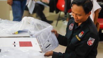 Petugas mengecek logistik Pilkada sebelum pendistribusian di Kantor Kecamatan Makasar, Jakarta, Selasa (26/11/2024). [Suara.com/Alfian Winanto]