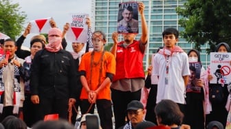 Massa membuat teaterika penangkapan Netanyahu saat aksi solidaritas untuk Palestina di depan Kedutaan Besar Amerika di Jakarta, Jumat (29/11/2024). [Suara.com/Alfian Winanto]