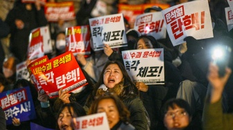 Orang-orang ambil bagian dalam protes yang menyerukan pengunduran diri Presiden Korea Selatan Yoon Suk Yeol di Majelis Nasional di Seoul, Korea Selatan, Rabu (4/12/2024). [Anthony WALLACE / AFP]