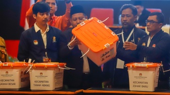 Petugas PPK Kecamatan Kemayoran membuka kotak berisi amplop form C hasil perhitungan suara disaksikan anggota KPU Kota Jakarta Pusat dan Bawaslu Kota Jakarta Pusat saat rapat pleno terbuka rekapitulasi hasil penghitungan perolehan suara dalam Pilkada serentak tahun 2024 di KotaJakarta Pusat, Rabu (4/12/2024). [Suara.com/Alfian Winanto]