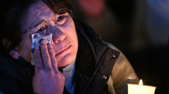 Seorang wanita bereaksi saat dia ambil bagian dalam acara peringatan lilin untuk memprotes Presiden Korea Selatan Yoon Suk Yeol di Seoul, Korea Selatan, Rabu (4/12/2024). [Philip FONG / AFP]