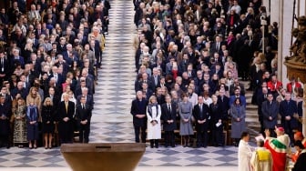 Para pemimpin dunia, politisi, dan tamu berdiri saat Uskup Agung Paris Laurent Ulrich (kanan) membacakan naskah dalam upacara pembukaan kembali Katedral Notre Dame di Paris, Prancis, Minggu (8/12/2024). [Ludovic MARIN/POOL/AFP]
