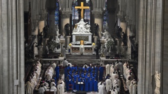 Uskup Agung Paris Laurent Ulrich (tengah belakang) memimpin doa untuk pentahbisan altar utama baru, selama misa dalam upacara pembukaan kembali Katedral Notre Dame di Paris, Prancis, Minggu (8/12/2024). [JULIEN DE ROSA / AFP]