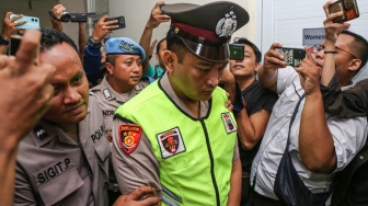 Terduga pelaku penembakan siswa SMK Aipda Robig Zainudin (tengah) digiring petugas memasuki ruang sidang kode etik kasus tersebut di Mapolda Polda Jateng, Semarang, Jawa Tengah, Senin (9/12/2024). [ANTARA FOTO/Makna Zaezar/aww]