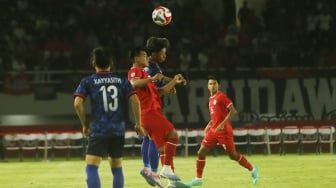 Bek Timnas Indonesia, Pratama Arhan berduel dengan pemain Laos dalam matchday kedua Grup B Piala AFF 2024 di Stadion Manahan, Solo, Kamis (12/12/2024). [Suara.com/Ronald Seger Prabowo]